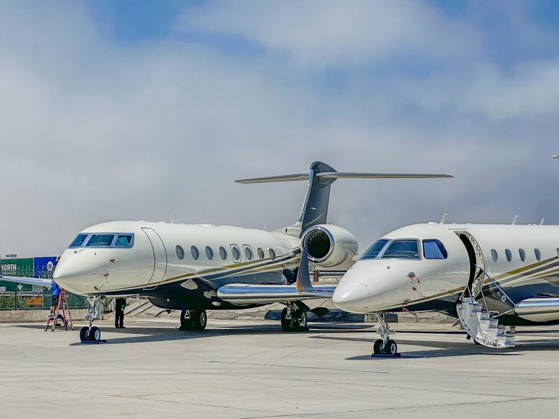 Two private jets parked side by side at the airport